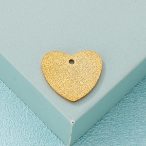 Frosted gold heart pendant accessory on a minimalist turquoise geometric background