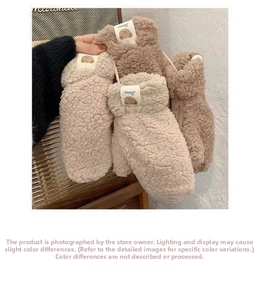 Detail view of plush teddy fleece mittens featuring a cute bear woven label for winter
