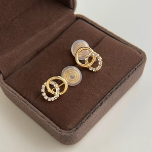 Detail of gold double-hoop clip-on earrings with pave crystals in a jewelry box