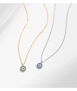 Detail of silver and gold evil eye necklaces with blue and white zircon pavé pendant