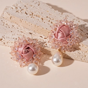 Detail of pink fabric rose earrings with crystal beads and teardrop pearl charms