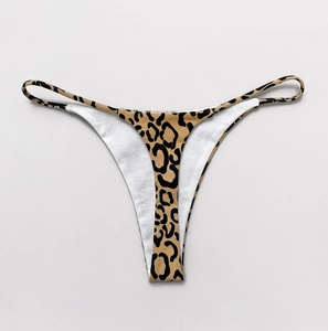 Detail view of sexy leopard print bikini thong with thin straps on white background