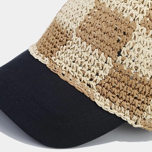 Detailed close-up of handmade crochet straw baseball cap with beige and brown woven pattern