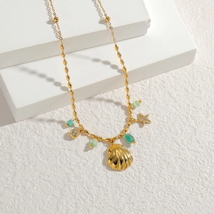 Vintage gold necklace with shell pendant, starfish charm and green beads on white steps