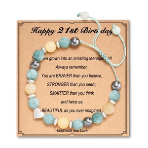 Detail of handmade beaded birthday bracelet with silver heart charm and motivational card