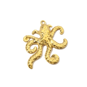 Macro view of gold-plated octopus pendant showing detailed texture and metal finish