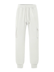 Detail of light gray quilted cargo pants showing the grid texture and elastic drawstring waist