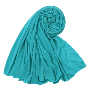 Detailed view of turquoise jersey scarf fabric texture and soft spiral draping style