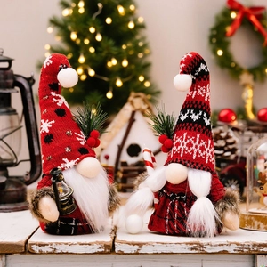 Christmas gnomes with knitted hats holding lantern and candy cane in festive setting