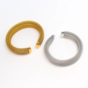 Close-up of elegant gold and silver C-shaped mesh bracelets with smooth metal ends