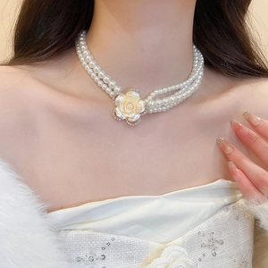Detailed view of a double-layer pearl choker with a diamond-encrusted cream rose pendant