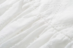 Detail showing white low-rise lace skirt with intricate embroidery and hollow patterns