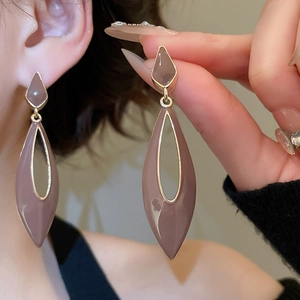 Detail of tear-drop hollow earrings in pink enamel and gold-plated finish on ear