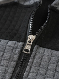 Macro shot of silver metal zipper on men's hoodie with textured checkered fabric detail