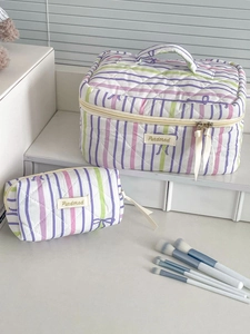 Detailed set of striped quilted cosmetic bags with bows on a display shelf
