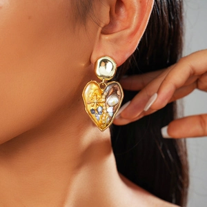 Close-up of vintage heart drop earrings with pearl and colorful enamel in gold finish