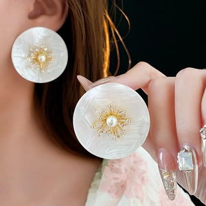 Detailansicht der Perlenohrringe mit Zirkonia-Inlay und goldenem Sonnenstrahl-Motiv