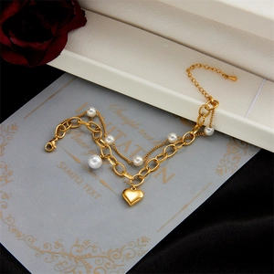 Double-layer gold chain bracelet featuring heart pendant and white pearls on card