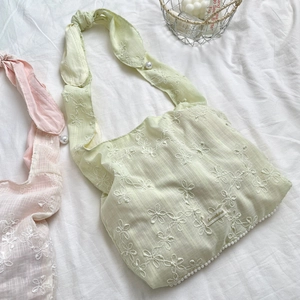 Detail der mintgrünen Chiffon-Tasche mit weißer Blumenstickerei und Perlenverzierung