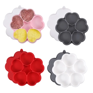 Macro view of four silicone baby food molds with heart compartments and matching lids