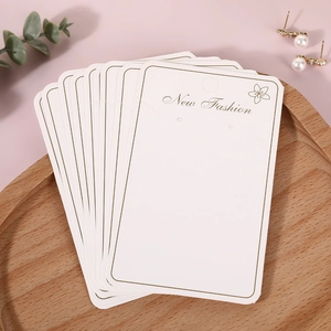 Elegant white jewelry display cards with gold foil New Fashion text on wooden tray