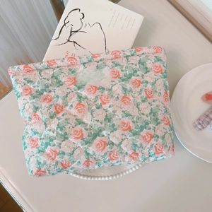 Detail of floral quilted cotton makeup bag with 'simple wish' label in aesthetic setting