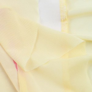 Gros plan sur la texture du tissu en maille jaune pâle et les détails de couture fins