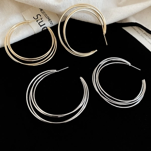 Detail von mehrlagigen C-Form Metall-Ohrringen in Gold und Silber für Damen