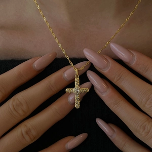 Cross pendant necklace with white zircons and gold chain on model, vintage jewelry style