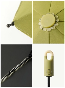 Close-up of green umbrella details: reinforced metal ribs, fabric seams, and matte handle