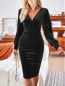 Vestido ajustado de terciopelo negro con cuello en V y manga larga en ambiente interior cómodo