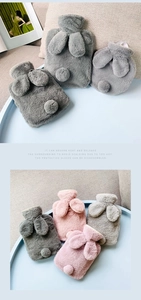 Detail of plush rabbit-shaped hot water bottles with soft faux fur and removable covers