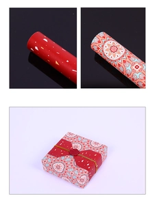 Détail de papier cadeau rouge aux motifs dorés et coffret cadeau mandala vintage