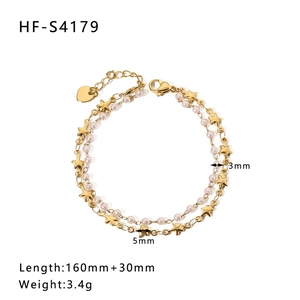 Detail of gold star pendant and small pearls on double-layer stainless steel bracelet