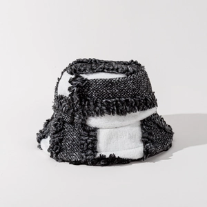 Detail of checkered wool bucket hat with plush texture and fringe edges in monochrome