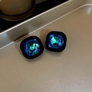 Détails de boucles d'oreilles vintage avec cristaux bleus sur un plateau métallique