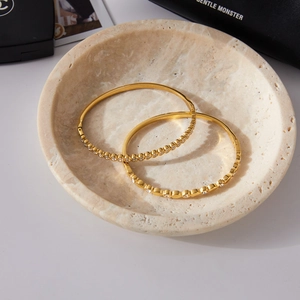 Bracelets luxueux en acier inoxydable doré avec cristaux blancs sur plateau en marbre