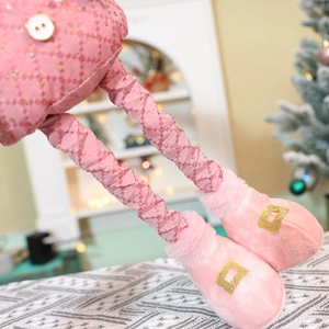 Detail of pink plaid fabric and sequined boots on telescopic Christmas plush toy