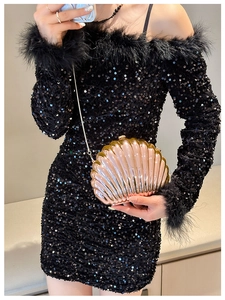Champagne gold shell evening clutch with chain strap on a black sequined dress