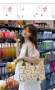 Detail of canvas tote bag featuring cute cartoon bear print in casual grocery store setting