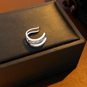 Detail of silver double-layer ear cuff featuring pave zircon stones on a jewelry box