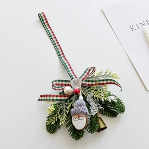 Christmas Santa ornament with pine needles, red plaid bow, and metal bell on white base