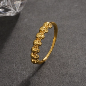 Anello dorato in stile gotico con una fila continua di teschi dettagliati in metallo