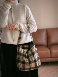 Détail du sac à bandoulière rétro en laine avec motif à carreaux vert foncé et marron