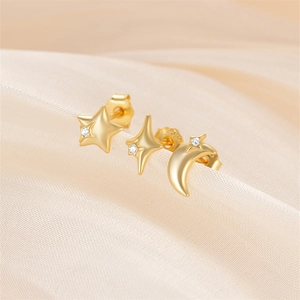 Macro shot of S925 silver studs with gold plating and zircons in star and moon shapes