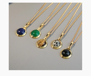 Detail showing five colors of oval tiger eye stone pendants on gold necklaces