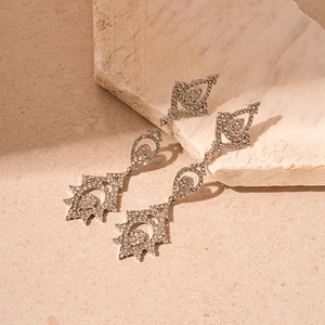 Boucles d'oreilles pampilles argentées avec cristaux étincelants sur marbre