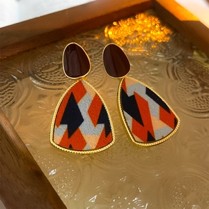 Detailed close-up of French vintage geometric fabric earrings with gold-plated metal edges