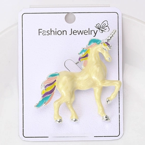 Detail of colorful enamel unicorn brooch with multi-color mane on a white display card