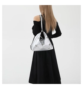 Silver metallic tote bag with butterfly metal plate shown on a shoulder